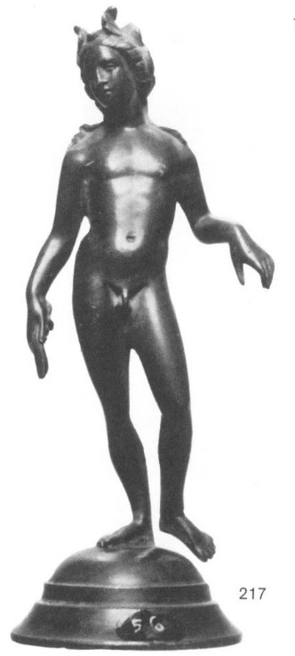 A black-and-white photo of a nude, feminine looking Apollo with acanthus looking leaves adorning His hair. He is perched on the statue's base with one foot while the other sways unattached, as if He is off-balance. His back looks arched while His left hand is held out with a limp wrist.